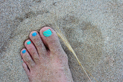 Low section of woman on sand