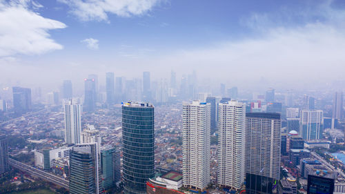 Aerial view of buildings in city against sky