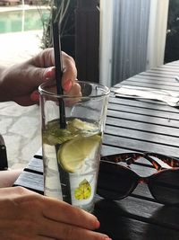 Hand holding glass of drink on table