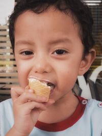 Portrait of boy eating ice cream at home