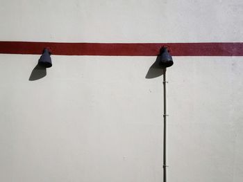 Bird perching on red umbrella