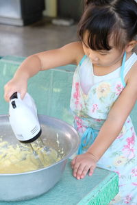 Rear view of girl holding food in bowl