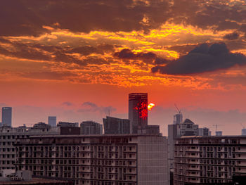 Buildings in city against sky during sunset