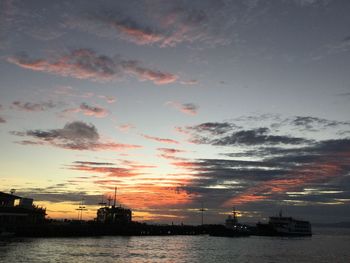 Silhouette boats sailing on sea against sky during sunset