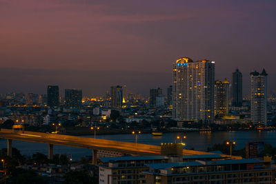 Illuminated buildings in city against sky at night