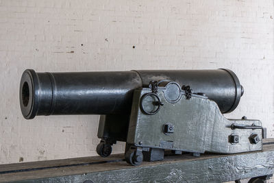 Close-up of machine part on table against wall