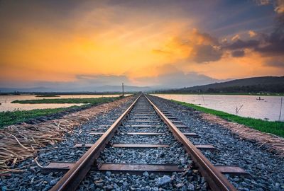 Railroad tracks against sky during sunset