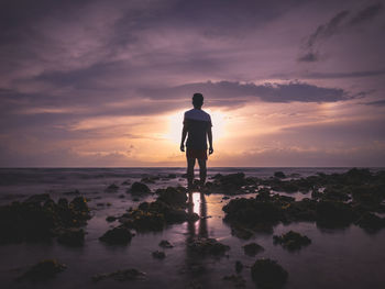 Rear view of man standing on beach