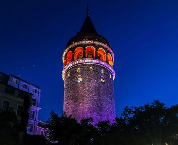 Low angle view of illuminated building against blue sky