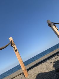 Low angle view of railing against blue sky