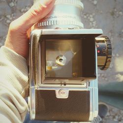 Close-up of cropped hand holding camera