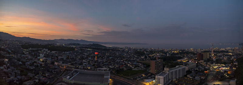 High angle view of illuminated city buildings at sunset