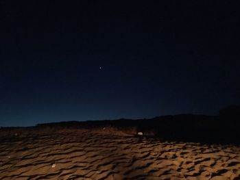 Scenic view of desert against clear sky at night