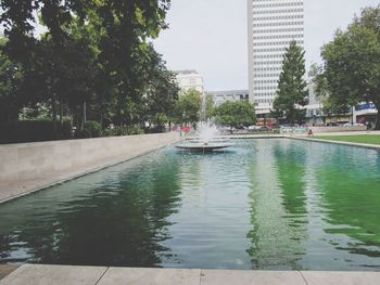 Swimming pool in city against sky