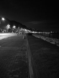 Illuminated beach against sky at night