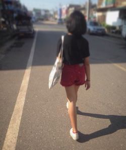 Rear view of woman standing on street