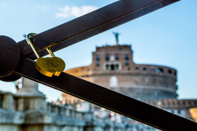 Close-up of padlocks on bridge against sky