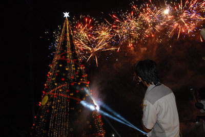 Rear view of firework display at night