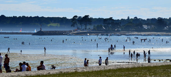 People enjoying in sea against sky