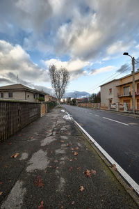 Road amidst buildings against sky in city