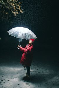 Rear view of woman with umbrella walking in rain