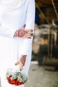 Midsection of woman holding rose bouquet