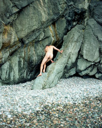 Low section of woman sitting on rock