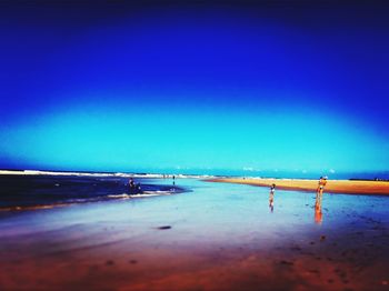 Scenic view of beach against clear blue sky