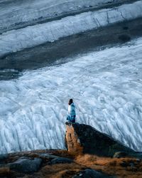 Rear view of man standing on snow covered landscape