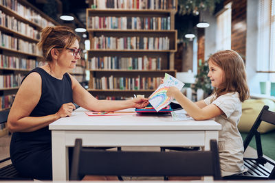 Teacher assisting schoolgirl during art class. child doing homework. primary school. learn and fun