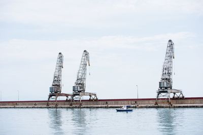 Crane by sea against sky