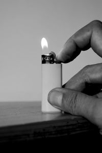 Close-up of hand holding lit candle