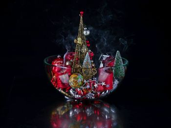 Close-up of christmas glass on table against black background