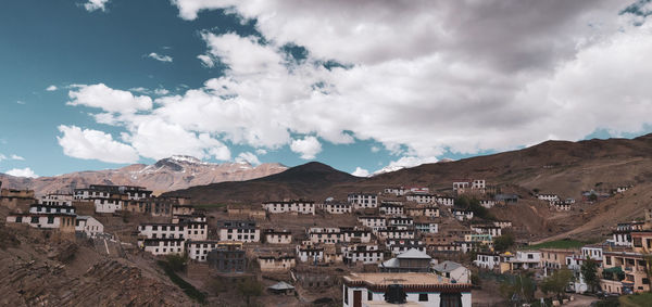 Panoramic view of townscape and mountains against sky