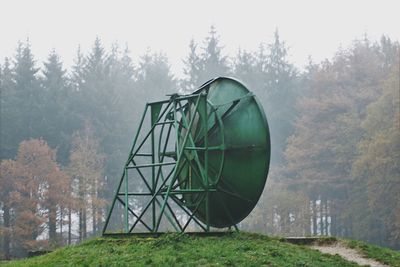 Built structure on field against trees in forest