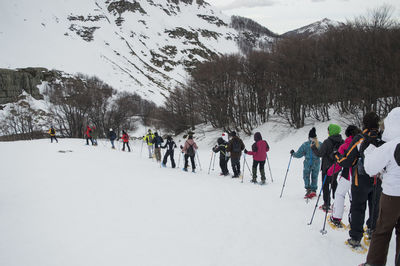 People skiing on snowcapped mountains during winter