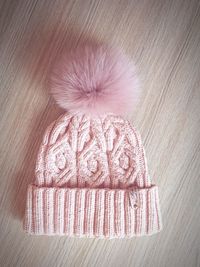 Directly above view of pink woolen knit hat on table