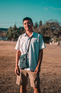 Portrait of young man standing on land