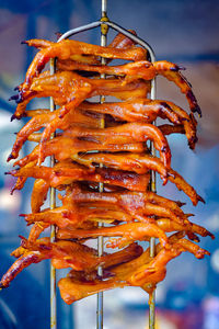 Small chickens roasted on skewers above a barbecue. vietnam.