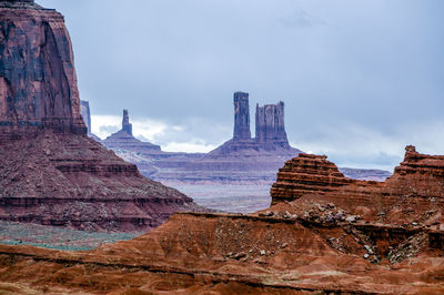 Rocky mountains at monument valley navajo tribal park against cloudy sky