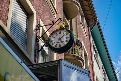 Low angle view of clock on building against sky