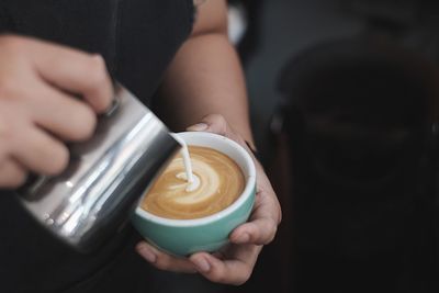 Midsection of man holding coffee cup