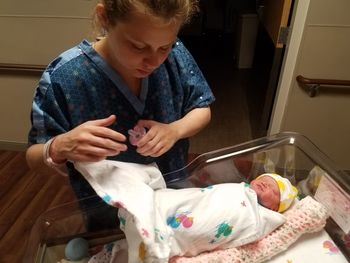 High angle view of mother standing by newborn baby in hospital