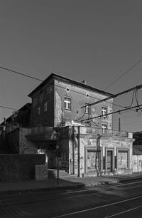 Road by buildings against clear sky