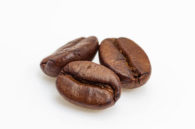Close-up of roasted coffee beans against white background