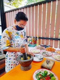 Woman wearing mask preparing spices