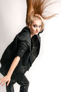 Portrait of beautiful young woman against white background