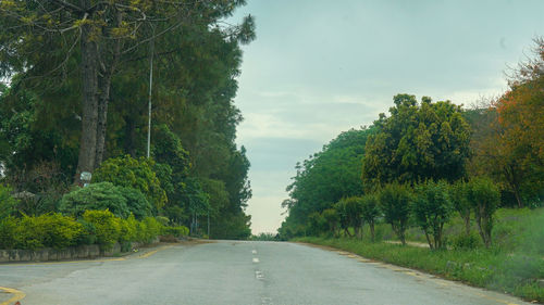 Road amidst trees against sky