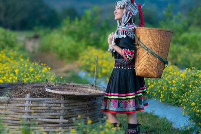 Woman holding basket while standing on field