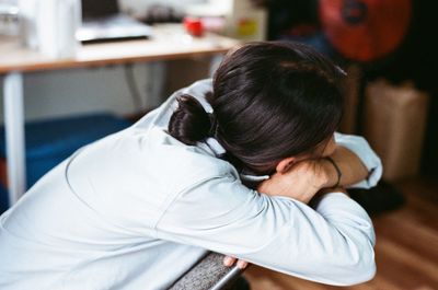 Side view of depressed woman sitting on chair at home